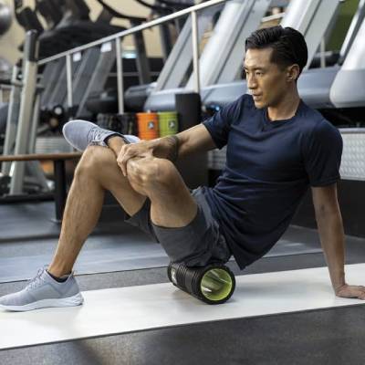 Athlete using TriggerPoint Grid Foam Roller for Glute and Leg Recovery